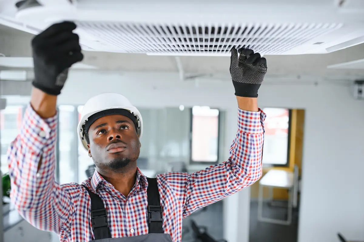 tecnico-africano-experto-reparando-aire-acondicionado empresa reparacion aire acondicionado